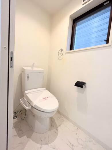 PLENDY三鷹401号室の温水洗浄便座付きトイレと窓のある白壁の空間